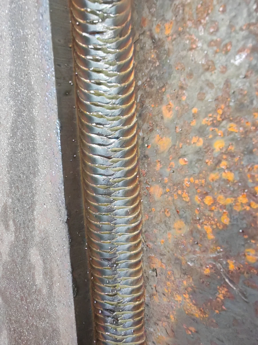 Close-up of a weld bead and the surrounding metal surfaces.